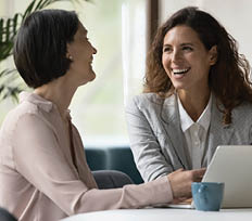 Two happy businesswomen, office employees work in office, laughing, joking during workflow, share creative ideas, solution feel satisfied with corporation, engaged in teamwork. Negotiation, business
